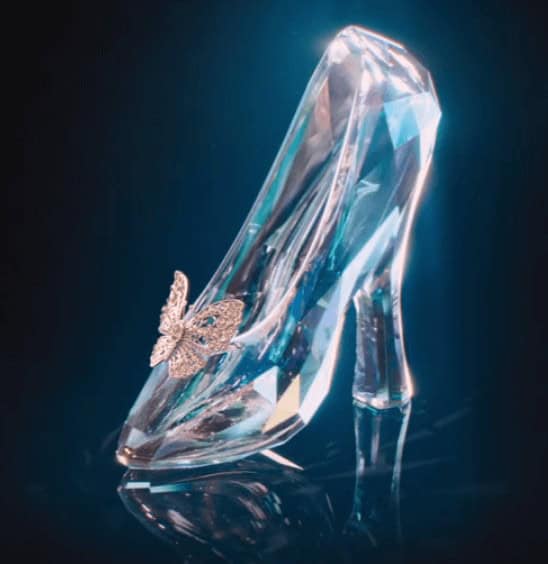 Cinderella’s iconic glass slipper, sparkling with a silver butterfly accent beneath a glowing dark blue backdrop, captures the magical allure guests experience at Disney theme parks during live-action Cinderella displays and attractions.