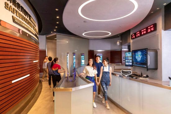 A group of people walking in a hall at Hong Kong Disneyland