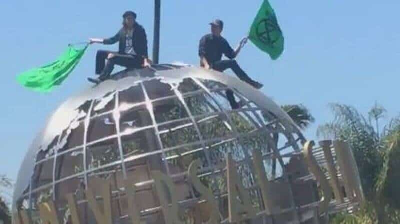 Two people sitting over Universal Studios' globe