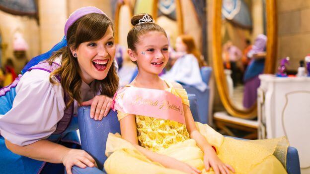 fairy godmother and young girl look into mirror at disney world bibbidi bobbidi boutique