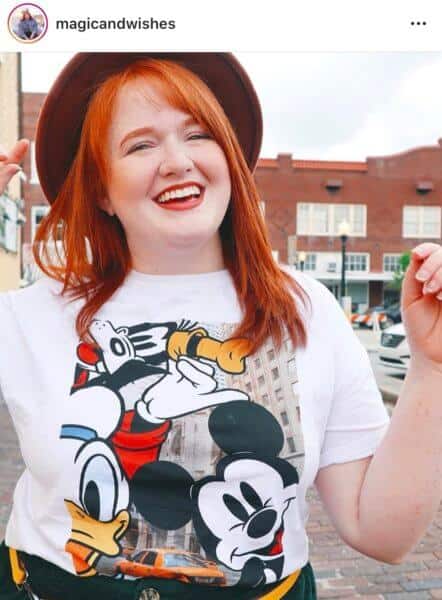 A woman wearing a hat and smiling on the street