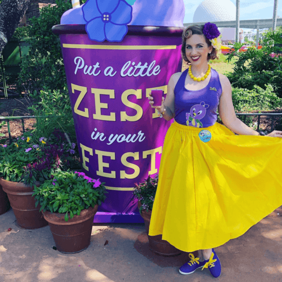 Woman Wearing Blue and Yellow Dress with background signage \"Put a little Zest in your Fest\"