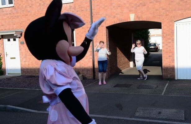 Real-life Minnie Mouse weaving to two women