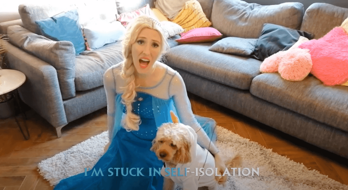 Girl dressed as Elsa from Frozen sitting in a living room with a dog