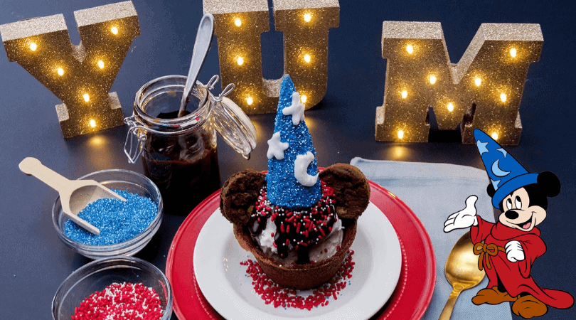 A table with a Mickey Mouse cupcake on a plate