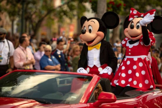 mickey and minnie riding in red car at disney's hollywood studios