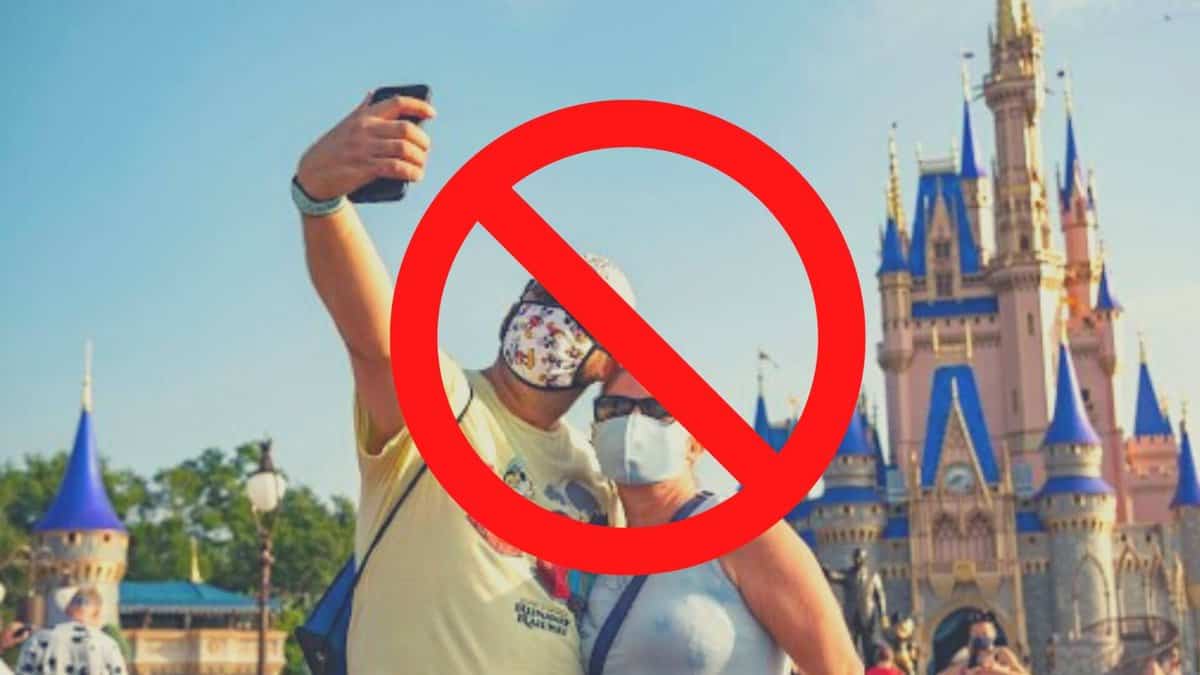 A Couple Taking  a Selfie in Sleeping Beauty Castle with a Not Allowed Sign