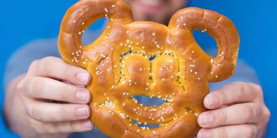 Two hands holding a Mickey Pretzel