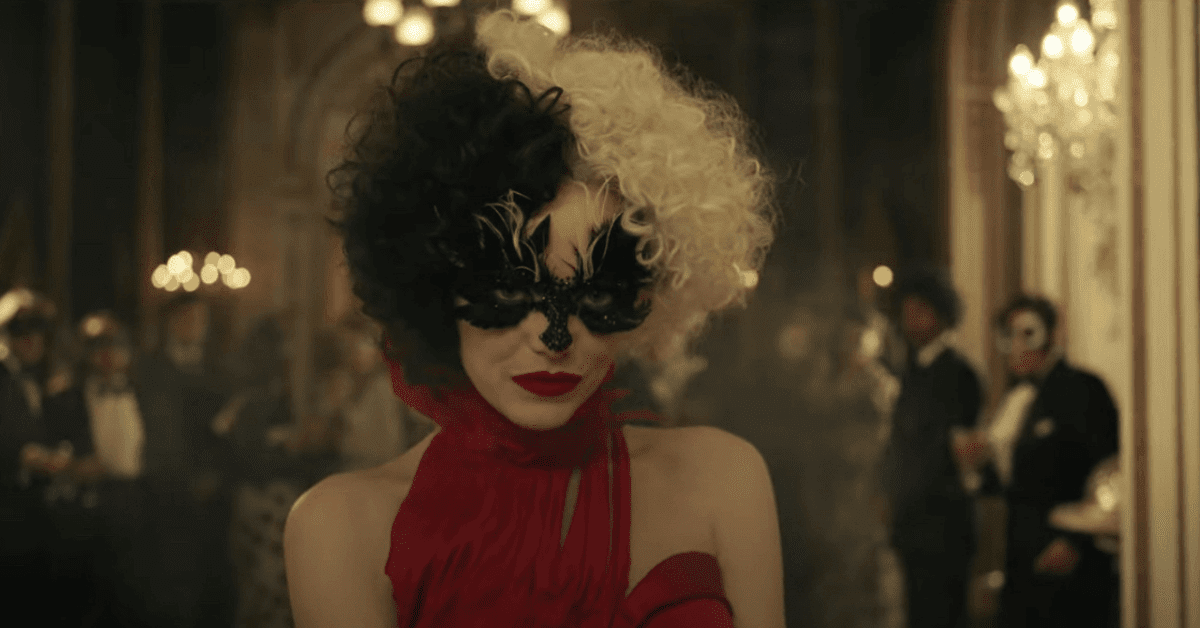 A person with black and white hair wearing a red dress