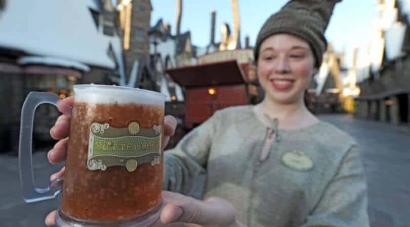 A person holding a large glass of beer