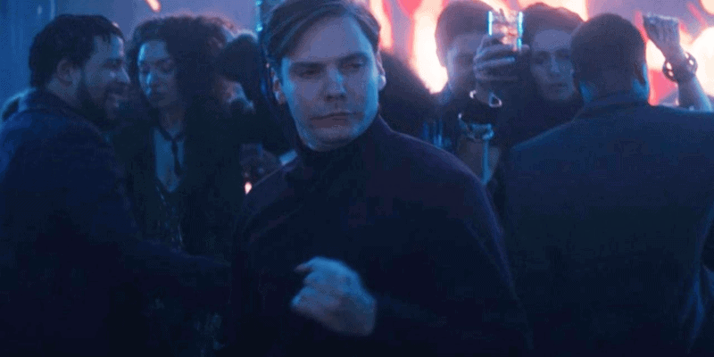 Daniel Bruhl standing in front of a crowd of people in a dark room