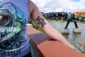 Tattoo on lady's bicep with amusement ride in the background