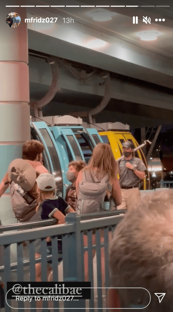 Families and kids eagerly wait by the iconic, vibrant Disney monorail inside the lively indoor station, ready to start their magical journey through the park.