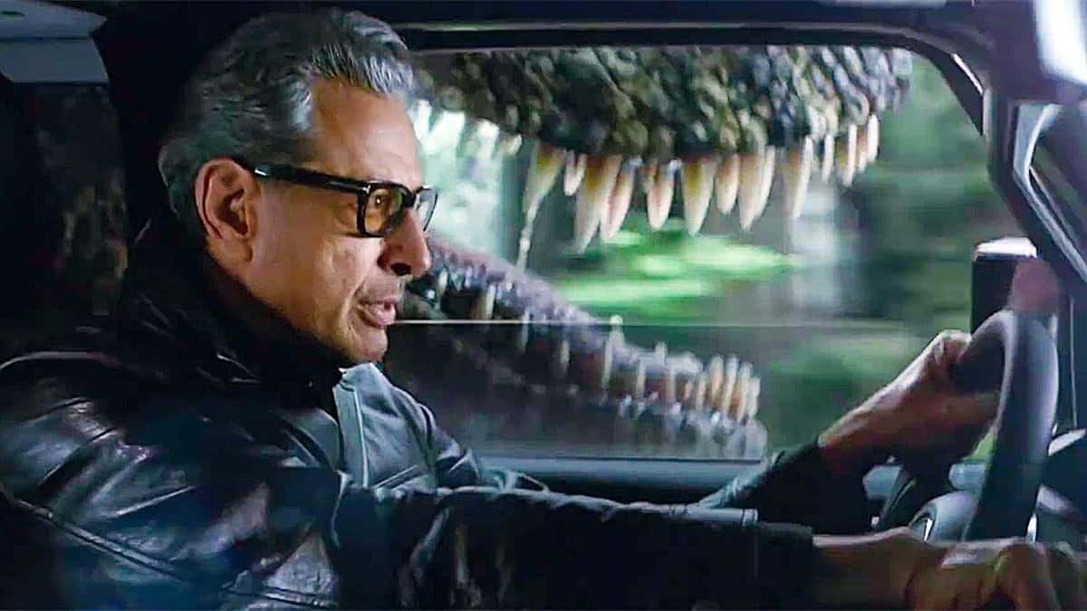 Side view of man with dinosaur teeth in background
