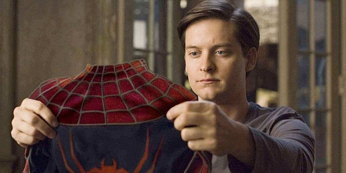 tobey maguire as peter parker holding spider-man suit