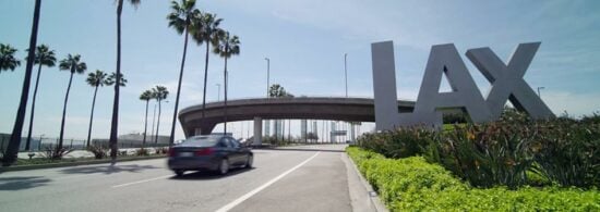 car driving by lax sign