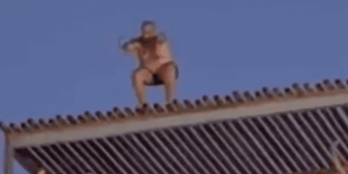 Man Climbs Roof at Water Park