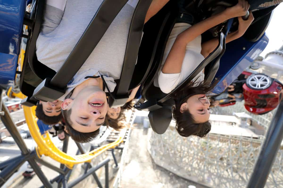Guests hanging upside down on a roller coaster at Six Flags theme park in California.