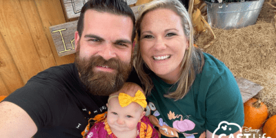 Lenny, his wife, and their young daughter at a pumpkin patch.