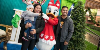 Light up the Season D23 photo of a family with Daisy Duck