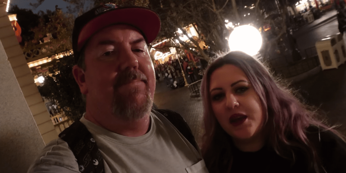 Katie & Spencer of Best Life & Beyond smiling in the dark at Disneyland.