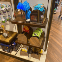 Plastic headbands inspired by Hades, Mike, Sulley, Anger, Malificient, and more sit on racks with mirrors available to check how you look.