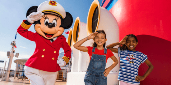 Captain Minnie standing with two girls on deck of a Disney Cruise Line ship
