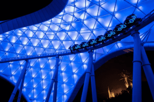 One of the banks on TRON Lightcycle/Run at night with a coaster car on it.