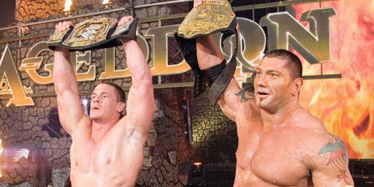 John Cena and Batista holding their titles at the Armageddon Pay Per View