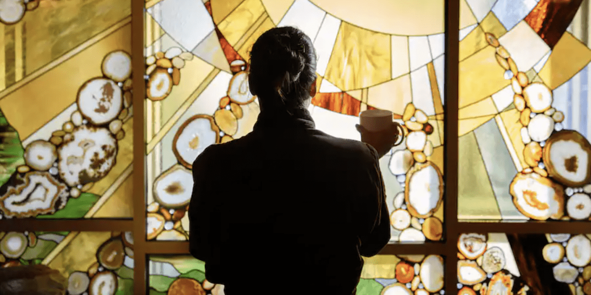 A woman standing in front of a colorful window