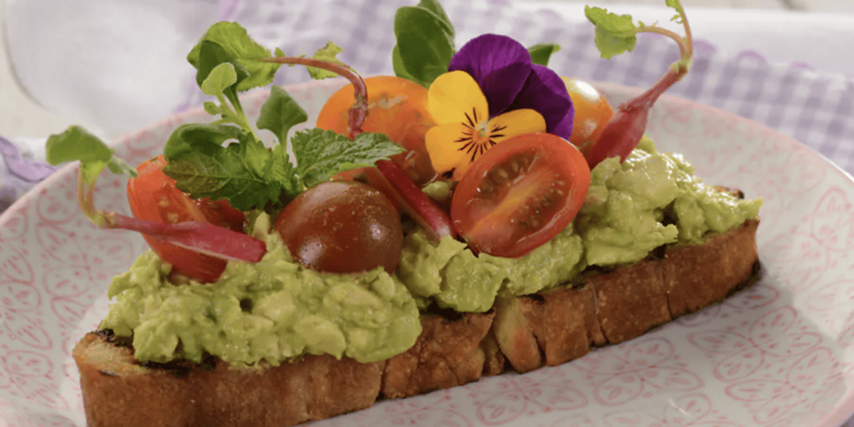Avocado toast with tomatoes and greens on top
