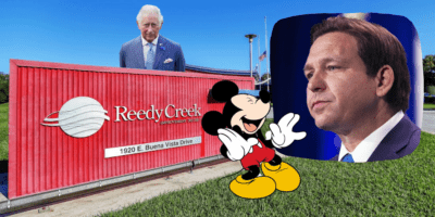 Mickey Mouse laughs at a picture of Ron DeSantis looking pensive. The two are pictured in front of a sign for Reedy Creek, which King Charles III is popping out from behind.
