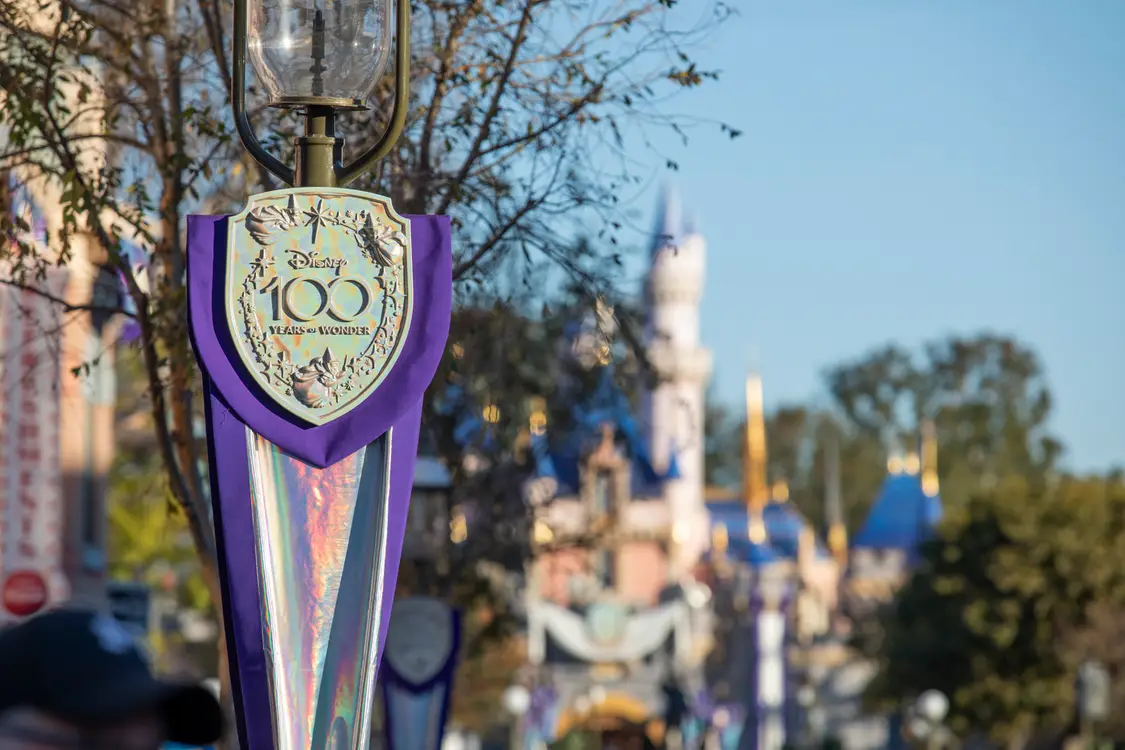 Disney100 banner with Sleeping Beauty Castle in the background at Disneyland Resort