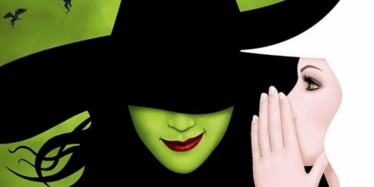 Glinda whispering into Elphaba's ear on Wicked poster