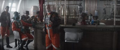 New Republic pilots including Trapper Wolf (Dave Filoni, wearing hat), Captain Carson Teva (Paul Sun-Hyung Lee, in center) with Bartender (Misty Rojas) in a scene from Lucasfilm's THE MANDALORIAN, season three, exclusively on Disney+. ©2023 Lucasfilm Ltd. & TM. All Rights Reserved.