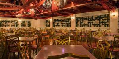 Tables and chairs in the PizzeRizzo wedding room under a disco ball