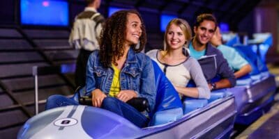 Three riders sit in their vehicle preparing to ride Space Mountain