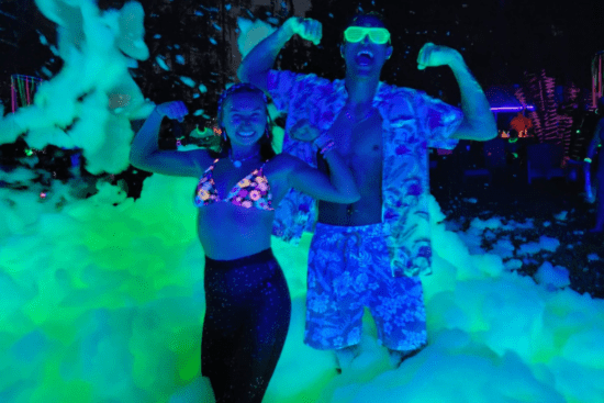 Two Guests in a neon foam pit at night at Islands H2O Water Park. 