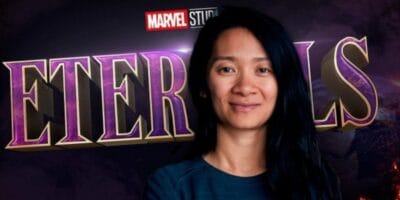 Chloe Zhao in front of the Eternals logo