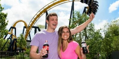Two Guests in front of a roller coaster at Six Flags Great America