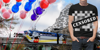 A man in a black tee shirt that is censored, referring to the Disney dress code debate. He stands in front of the Monorail going past the Matterhorn at Disneyland.
