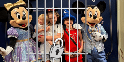 Three children pose with Mickey and Minnie Mouse on their Disney vacation.