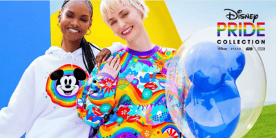 Two women model rainbow attire from the Disney pride merch collection.