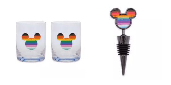 Two clear shot glasses with rainbow Mickey Mouse heads on them, the same rainbow Mickey Mouse head on the top of a black bottle stopper 
