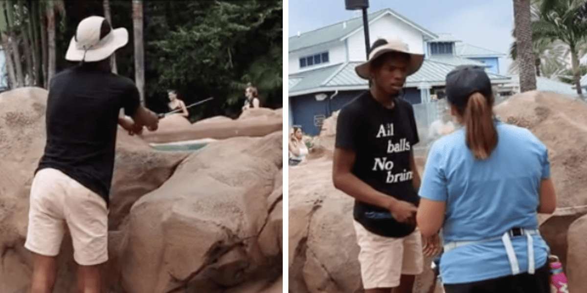 A man fishing in a petting tank at SeaWorld, the same man being spoken to by a SeaWorld employee.
