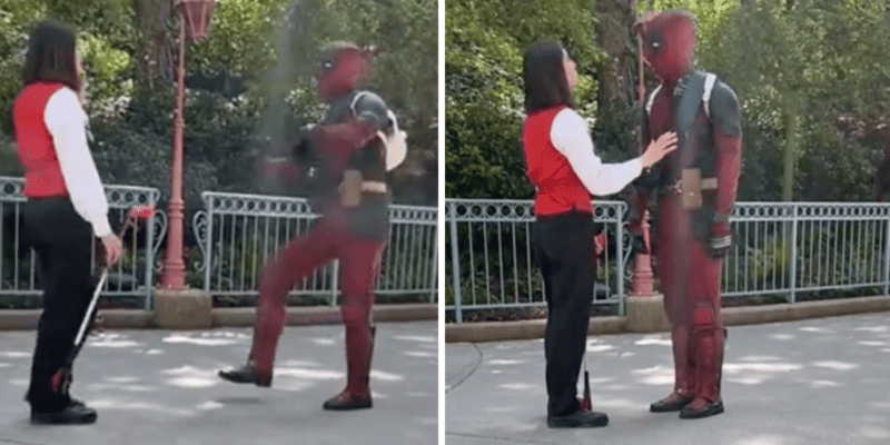 An influencer breaking the disney dress code in a deadpool costume speaking to a disney cast member.