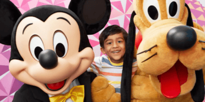 Child enjoying a character experience with Mickey and Pluto at exclusive Disney Cardmember Spot in EPCOT
