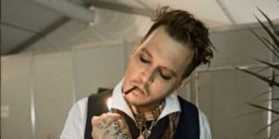 johnny depp lighting a cigarette backstage at hollywood vampires lisbon, portugal show
