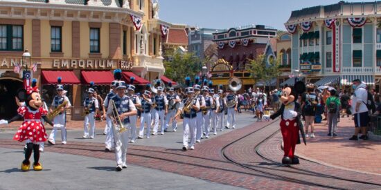 The band marches down Main Street, U.S.A. at Disneyland with Mickey and Minnie Mouse