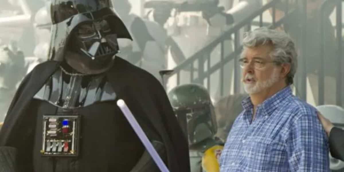 George Lucas wielding a lightsaber while talking to Darth Vader